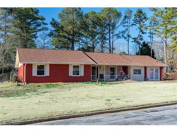 Charming single-story home with a red brick exterior and a well-manicured front yard at 1830 Brandy Se Ln, Conyers, GA 30013