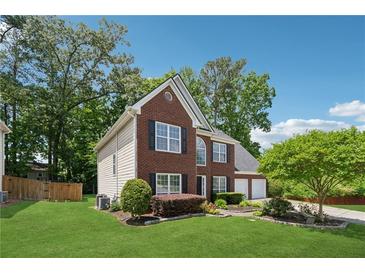 Charming two-story brick home with a well-manicured lawn, and mature trees enhancing its curb appeal at 6034 Farmwood Se Way, Mableton, GA 30126