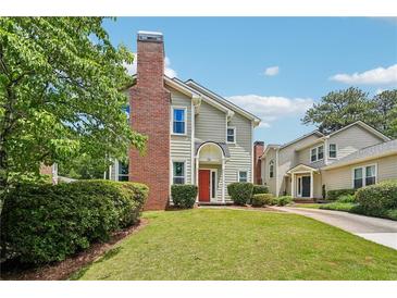Charming townhome featuring a red front door, brick chimney, and well-manicured lawn at 267 Somerlane Pl, Avondale Estates, GA 30002