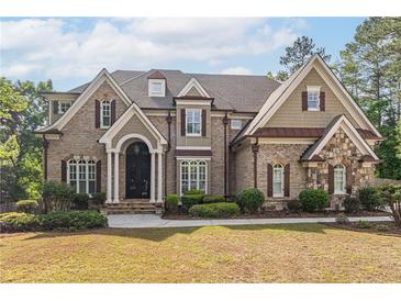 Charming two-story brick home featuring manicured lawn and mature trees at 1584 Water Springs Way, Dacula, GA 30019