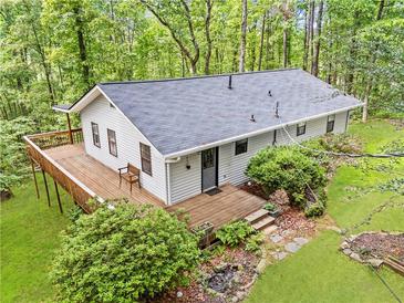 View of home with a new roof, expansive deck, surrounded by lush forest at 6650 Bobby John Rd, Atlanta, GA 30349