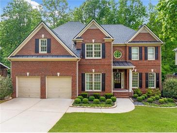 Traditional brick home featuring an attached two-car garage and manicured lawn at 790 Sienna Dr, Cumming, GA 30040