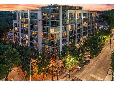Beautiful mid-rise apartment building with glass windows and balconies, surrounded by mature trees at sunset at 905 Juniper Ne St # 808, Atlanta, GA 30309
