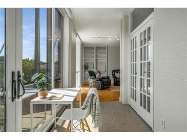 Bright sunroom with a desk, and the doorway leads into a living room with built-in bookshelves at 130 26Th Nw St # 415, Atlanta, GA 30309