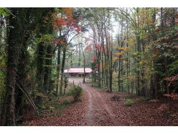 Scenic view of home nestled in a wooded lot featuring mature trees and a long driveway at 618 Old Doss Dr, Canton, GA 30115