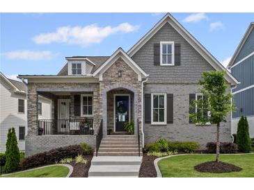 Charming home featuring brick and stone accents, a cozy front porch, and a well-manicured lawn at 2003 Haley Walk, Woodstock, GA 30188