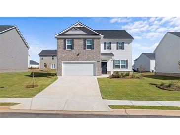 Charming two-story home with a brick and siding exterior, attached garage, and well-manicured lawn at 45 Vermillion Trl, Covington, GA 30016