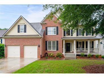 Charming brick and siding two-story home with a well-manicured lawn and a welcoming front porch at 138 Knightwood Pt, Acworth, GA 30101
