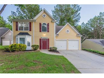 Charming two-story home with a well-manicured lawn, two-car garage, and inviting red front door at 7113 Ambercrest Ct, Austell, GA 30168