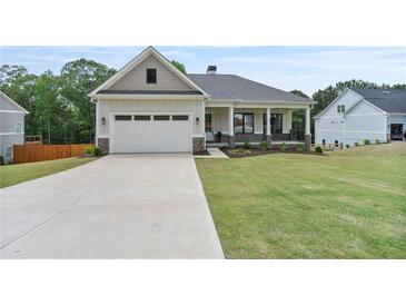 Charming single-Gathering home with a manicured lawn, attached garage, and inviting covered porch at 6830 Heard Ln, Cumming, GA 30041