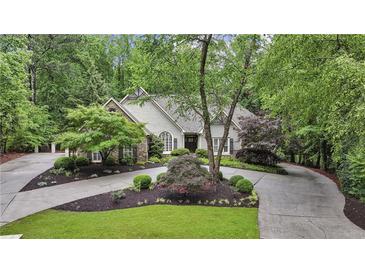 Inviting traditional home featuring stone accents, mature landscaping, and a circular driveway at 905 Brooksglen Dr, Roswell, GA 30075