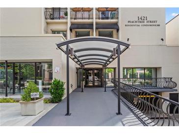 Inviting entrance to 1421 Peachtree Street Residential Condominiums with covered walkway and adjacent storefronts at 1421 Peachtree Ne St # 304, Atlanta, GA 30309