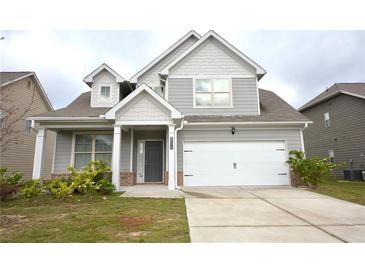 Charming two-story home with gray siding, a covered porch, and a two-car garage at 2522 Bear Mountain St, Lithonia, GA 30058