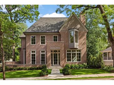 Elegant brick home featuring a landscaped front yard, large windows, and a classic architectural design at 27 Maddox Ne Dr, Atlanta, GA 30309