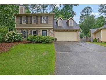 Charming two-story home featuring stone accents, a two-car garage, and a well-manicured front lawn at 3470 Whisperwood Nw Ct, Marietta, GA 30064