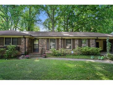 Charming brick home featuring wood shutters, a well-maintained lawn, and mature trees for shade and curb appeal at 2175 Fisher Ne Trl, Atlanta, GA 30345
