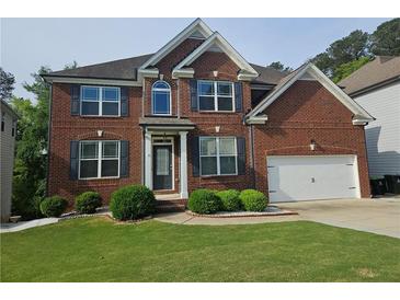 Charming two-story brick home with a well-manicured lawn and a two-car garage at 232 Clubhouse Xing, Acworth, GA 30101
