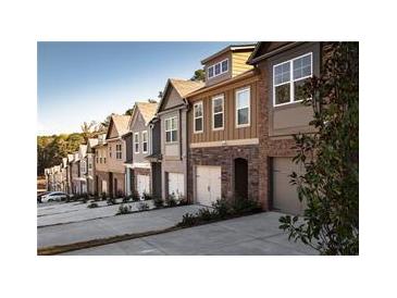 Charming row of townhomes featuring varied facades and attached garages on a tree-lined street at 2692 Avanti Way, Decatur, GA 30035
