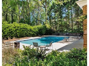 Backyard swimming pool with chairs in a lush green setting with mature trees and greenery at 3456 Paces Nw Pl, Atlanta, GA 30327