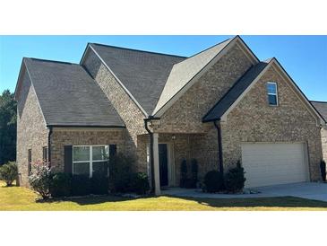 Charming single-Gathering home with a brick facade, manicured lawn, and a two-car attached garage at 457 Panhandle Pl, Hampton, GA 30228