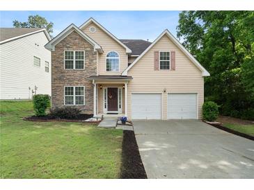 Charming two-story home boasts a stone facade, two-car garage, and well-manicured front yard at 237 River Pass Ct, Dacula, GA 30019