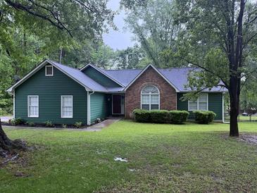 Charming one-story home featuring a brick accent, dark green siding, and a lush front lawn at 608 Fairhaven Blvd, Stockbridge, GA 30281