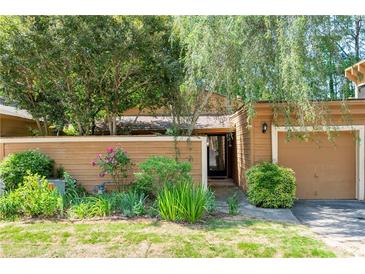 Charming home featuring a cozy front entrance with a quaint, fenced front yard and mature landscaping at 845 Lake Hollow Sw Blvd, Marietta, GA 30064