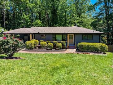 Charming single-story home with a lush, green lawn and mature trees in a tranquil setting at 3193 Trasher Cir, Decatur, GA 30032