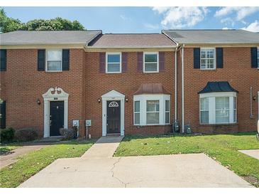 Traditional brick townhouse with a well-maintained front yard and private driveway at 1507 Paces Ferry North Se, Smyrna, GA 30080