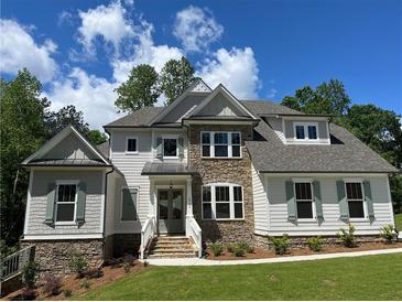 Beautiful two-story home with a stone and siding exterior, well-manicured lawn, and professional landscaping at 3730 Reserve Overlook (Lot 8) Way, Cumming, GA 30041
