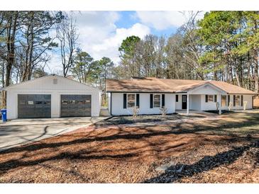Charming ranch-style home featuring a two-car garage and well-maintained front yard at 2401 Phillips Rd, Lithonia, GA 30058
