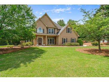 Charming two-story home with manicured lawn and mature trees in a desirable neighborhood at 2455 Ivey Oaks Rd, Cumming, GA 30041