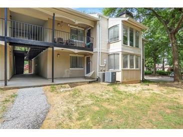 Exterior of building featuring balconies, stairs, stucco, and well maintained surroundings at 1303 Wingate Way, Atlanta, GA 30350