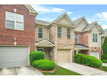 Charming brick townhome featuring a one car garage, well-maintained landscaping and craftsman details at 1622 Honeysuckle Path, Conyers, GA 30012