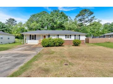 Charming single-story home featuring a well-maintained yard and a classic design with a cozy front porch at 2664 Olive Springs Se Rd, Marietta, GA 30060