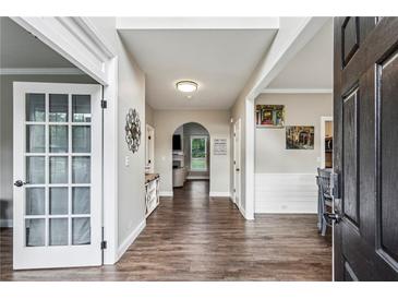 Inviting hallway featuring wood-look floors and neutral paint, leading to various rooms and areas of the home at 321 Woodbrook Crst, Canton, GA 30114