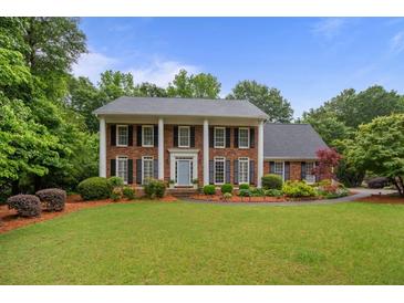 Beautiful two-story brick home with a well-manicured lawn and a charming blue front door at 3510 Smoke Rise Way, Lawrenceville, GA 30044