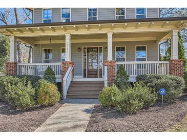 Charming home featuring a welcoming front porch with swing, brick accents, and beautiful landscaping at 2987 Jefferson St, Atlanta, GA 30341
