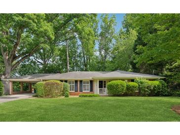 Charming single-story home with a well-manicured lawn, mature trees, and a convenient covered parking area at 500 Read Ln, Atlanta, GA 30328