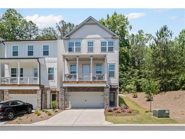 Two-story townhome showcases a private, covered porch and a two-car garage at 507 Bishop Ln, Woodstock, GA 30188