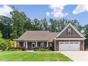Charming home boasts a manicured lawn, inviting entrance, and a two-car garage, blending comfort with curb appeal at 59 Grand Georgian Ne Ct, Cartersville, GA 30121
