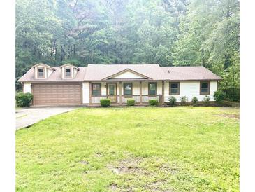 Charming single-story home with a well-maintained lawn and an attached two-car garage at 6832 Shangrila Way, Riverdale, GA 30296