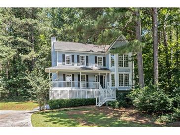 Charming two-story home boasts a covered porch and inviting curb appeal nestled amongst mature trees at 3 Maplelake Dr, Acworth, GA 30101