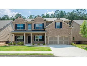 Charming two-story brick home with a well-manicured lawn, covered porch, and a two-car garage at 3405 Linstead Ct, Loganville, GA 30052