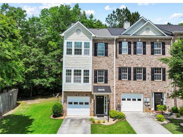 Charming townhome with brick and siding exterior, featuring a garage and well-maintained landscaping at 2138 Mill Garden Run, Buford, GA 30519