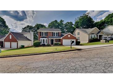 Charming two-story brick home with a manicured front lawn and attached two car garage at 4954 Penscot Way, Stone Mountain, GA 30088