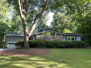 Charming one-story home with stone accents and a well-maintained lawn with mature shade trees at 1260 Willeo Creek Dr, Roswell, GA 30075