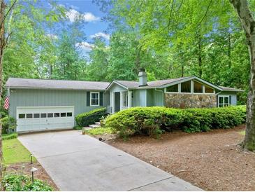 Charming one-story home with a long drive, mature trees, and stone accents at 1260 Willeo Creek Dr, Roswell, GA 30075