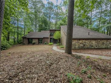 Charming home featuring stone accents and wooded surroundings at 3835 Shawnee Sw Run, Lilburn, GA 30047
