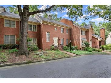 Beautiful red brick townhome with manicured landscaping and a charming front entrance with mature trees at 40 Ivy Chase Ne, Atlanta, GA 30342